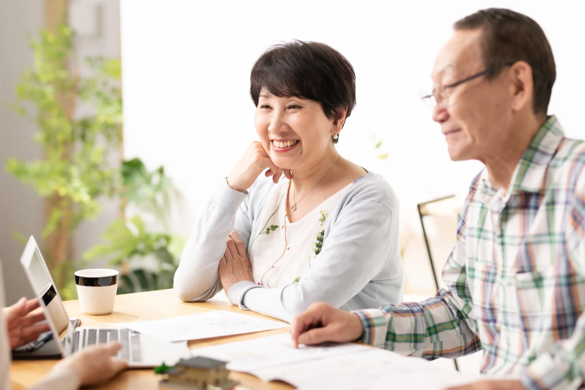 相続について笑顔で相談するご夫婦と、資料を前に説明する担当者